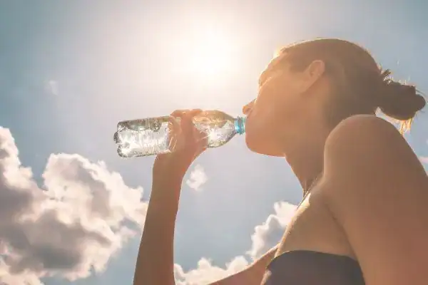 Hydration: The Secret Ingredient for a Toned Stomach and Enhanced Fitness 3 Image of woman drinking water to hydrate Berkshire after run.